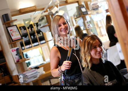 Ein Friseur dargestellt an einem jungen Mädchen die Haare zu einem Friseure in Chichester, West Sussex, UK. Stockfoto