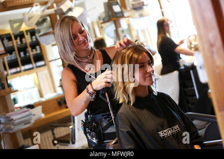 Ein Friseur dargestellt an einem jungen Mädchen die Haare zu einem Friseure in Chichester, West Sussex, UK. Stockfoto