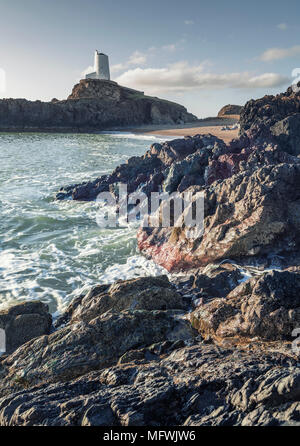 Felsigen Ufer mit alten lighhouse auf Felsen im Hintergrund. Ynys LLanddwyn im Nordwesten Anglessey, Wales, Großbritannien Stockfoto