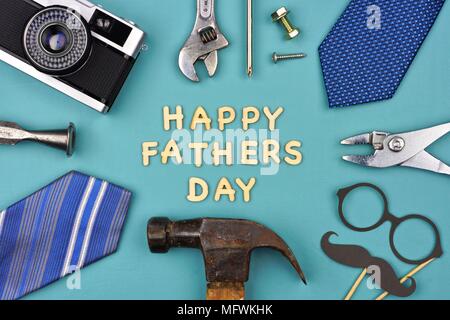 Happy Vatertag Nachricht mit Rahmen von Geschenken, Dekor, Krawatten und Tools auf einem blauen Hintergrund. Ansicht von oben, Stockfoto