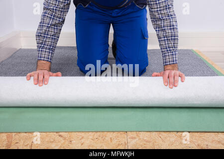 Nahaufnahme eines männlichen Arbeitnehmers Hand Einbau Teppich Stockfoto
