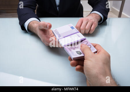 In der Nähe von zwei Geschäftsleute Holding Bündel Banknoten in Office Stockfoto