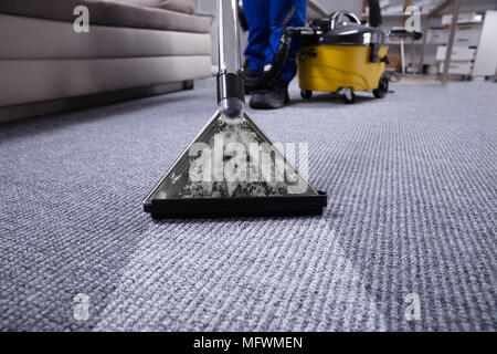 Der Hausmeister Hand Reinigung Teppich mit Staubsauger Stockfoto