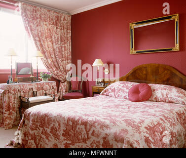 Doppelbett mit rosa und weißen Toile de Jouy Bettwäsche und passenden Vorhängen Stockfoto