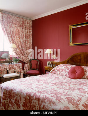 Doppelbett mit rosa und weißen Toile de Jouy Bettwäsche und passenden Vorhängen Stockfoto