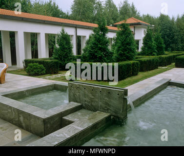 Wasser cascading in Garten Pools vor der Fassade der Villa Stockfoto