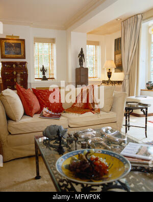 Die gepolsterten Sofas mit roten Kissen vor Glas Couchtisch Stockfoto