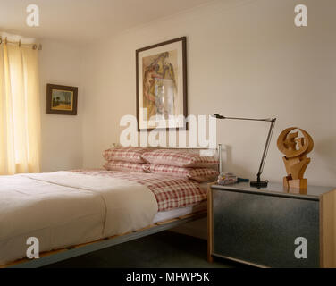 Metall Bett mit Karomuster Bettwäsche nächsten Cabinet zu Bett Stockfoto