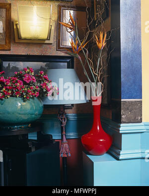 Störende Objekte einschließlich red Vase von Bird of paradise Blumen weiter zu Lampe und Keramik Vase mit Blumen Malerei verdecken. Stockfoto