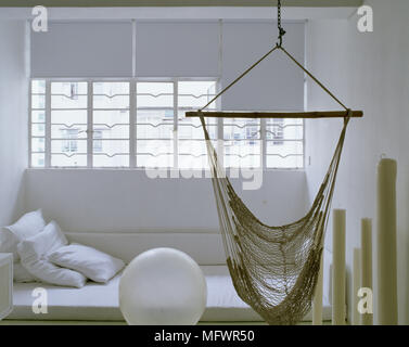 Weiße Zimmer mit Hängematte vor große Kerzen und Kissen ausgesetzt Stockfoto