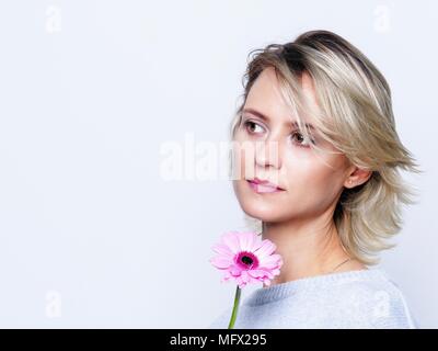 Romantische Frau mit rosa Blume. Stockfoto