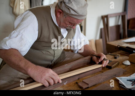 Schreiner in authentischen frühen amerikanischen Kleidung in seinem Geschäft durch seine authentische Werkzeuge in Colonial Williamsburg Virginia Umgeben arbeiten Stockfoto