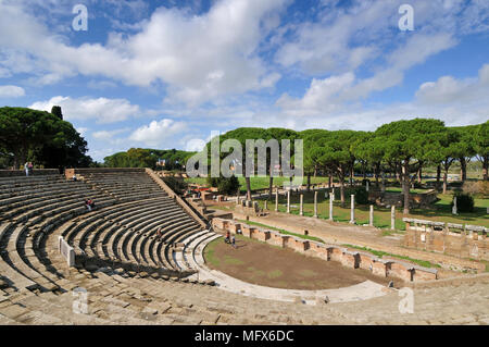 Das Theater und, im Hintergrund, der Marktplatz von Ostia Antica. An der Mündung des Flusses Tiber, Ostia war Roms Seaport zweitausend Jahre ag Stockfoto