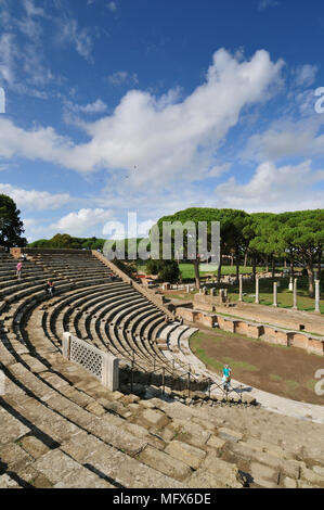 Das Theater und, im Hintergrund, der Marktplatz von Ostia Antica. An der Mündung des Flusses Tiber, Ostia war Roms Seaport zweitausend Jahre ag Stockfoto