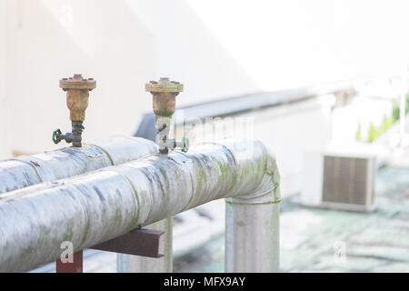 Rostige alte Heizung Kühlung Wasser Wasserleitungen mit Ventilen im Krankenhaus. Stockfoto