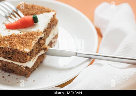 Stück hausgemachter Karottenkuchen, weiße Platte, Serviette. Messer schneidet ein köstliches Stück. Süße gesunde vegane Ernährung. Selektiver Fokus, kopieren Raum Stockfoto