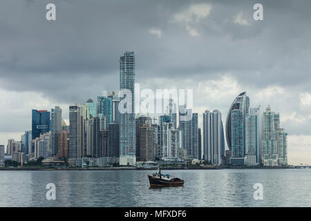 Die Hochhäuser der modernen Panama City, Panama, mit einem kleinen Fischerboot im Vordergrund. Stockfoto