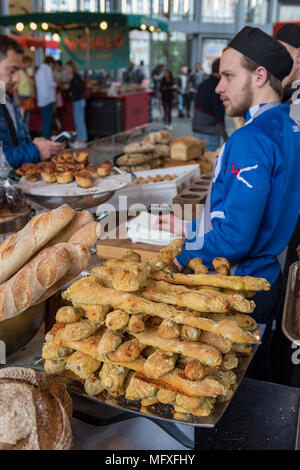 Eine handwerkliche Bäckerei am Borough Market in Central London mit einem Bäcker in einem Gespräch mit einem Kunden über die Backwaren und verschiedenen Brotsorten Verkauf anfragen Stockfoto