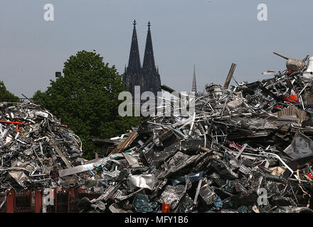 27 April 2018, Deutschland, Köln: die Türme des Kölner Doms kann hinter einem Hügel von Schrott in den Räumlichkeiten eines Junk Yard zu recicyling alte Metalle im Hafen in Deutz widmet. Foto: Oliver Berg/dpa Stockfoto