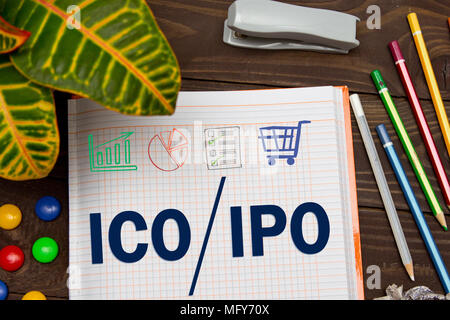 Notebook mit einem Geschäft Anmerkungen ICO erste Münze bietet vs IPO Initial Public Offering im Office Tabelle mit Tools. Konzept IPO und ICO mit ELEME Stockfoto