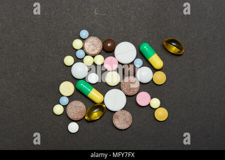 Opioid Epidemie. Opioid Pillen. Drogenmissbrauch Konzept - Verschiedene farbigen Pillen auf schwarzem Hintergrund. Stockfoto