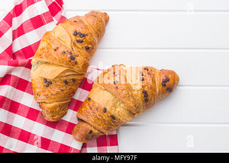 Zwei Croissants mit Schokolade Krümel auf weißer Tisch. Ansicht von oben. Stockfoto