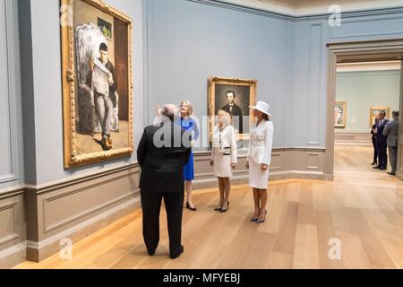 First Lady der USA Melania Trump, rechts, und Brigitte Längestrich, die Frau des französischen Präsidenten Emmanuel Längestrich Ansicht Gemälde von Paul Cezanne mit National Art Gallery Kuratorin Mary Morton, Zentrum darstellen, und der Stellvertretende Direktor Frank Kelly, Links, 24. April 2018 in Washington, DC. Die ersten Damen tourte eine Ausstellung von ca. 60 Porträts von der Französischen post-impressionistischen Maler Paul Cezanne. Stockfoto