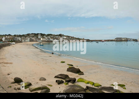 Blick über die St. Mary's Harbour, Scilly-inseln übersicht Stadt mit leeren Strand Golden Sands, einer ruhigen, blauen Meer und Hughtown. Hellblau Morgenlicht. Stockfoto