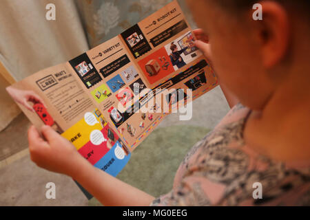 Ein junges Mädchen das Lesen einer Nintendo Labo Dokument an ihrem Haus in London, UK. Stockfoto