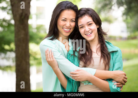 Asiatische Mutter Lachen und huging Ihr Kind. Stockfoto