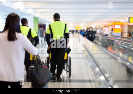 Verschwommenes Konzept Hausmeister drücken ältere Menschen im Rollstuhl im Flughafen Stockfoto
