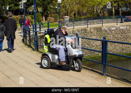 26. April 2018 eine 94-jährige Seniorin auf einer Behinderung Roller an der Küste in Bangor Northern Ireland an einem kalten, aber hell und Stockfoto