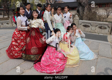 Gruppe der koreanischen Jugendlichen in traditionelle bunte hanbok Kleidung, posieren für Fotos, blinkt der Sieg unterzeichnen, an Changdeokgung-palast, Seoul. Stockfoto