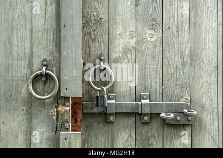 Vintage Schieber und alte hölzerne Tore mit runden Griffe aus Metall in Form von Ringen. Stockfoto