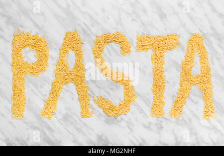 Das Wort "PASTA" auf Marmor Hintergrund, mit Reis-förmige winzige Orzo pasta geschrieben. Stockfoto