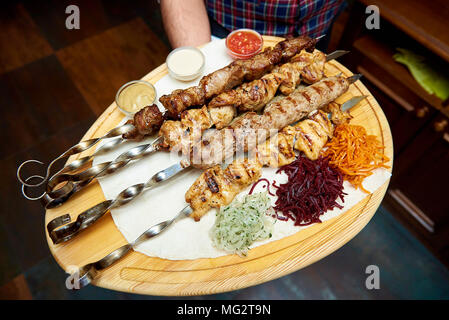 Sie warme Shish Kebab mit Gemüse und Sauce in einem Restaurant. Stockfoto