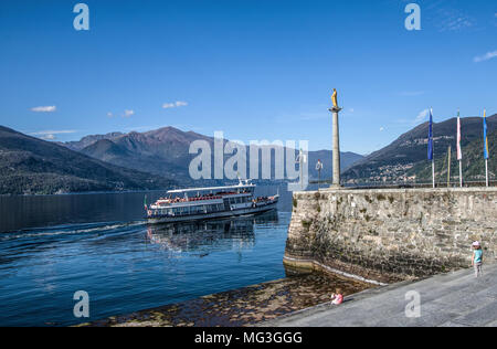 Ein Boot segeln vor dem kleinen Hafen der Madonnina, Luino am Lago Maggiore, Italien Stockfoto