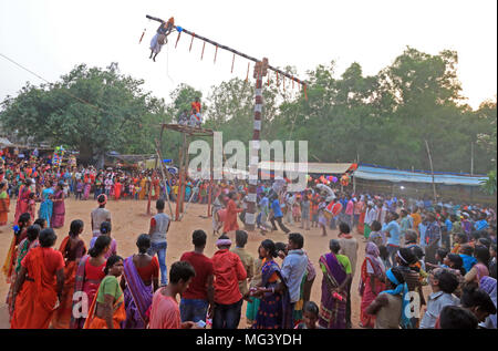 Charak Puja, Bangladesch. 26. April 2018. Tribal Leute beobachten, die wundersame Akrobatik durch ein Devotee während der 'Charak Festival', die gerade ausgeführt wird oder der Parab antali Pata". Der wichtige Teil Gajan Festival ist Charak Puja. Die Tradition der Charak Puja ist alles über die Anbetung des Charak Baum und mehrere Buße taten durch Charak Sanyasis rund um und auf dem Baum durchgeführt. Die Charak Baum ist ein Stamm eines Baumes ohne Wurzeln oder Äste. Die Höhe wird ca. 30 bis 40 Fuß. Die erstaunliche Teil ist, wie sanyasi Credit: PACIFIC PRESS/Alamy leben Nachrichten Stockfoto