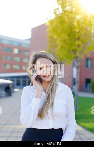 Blonde junge geschäftsfrau, draußen im Business Center im Freien Stockfoto