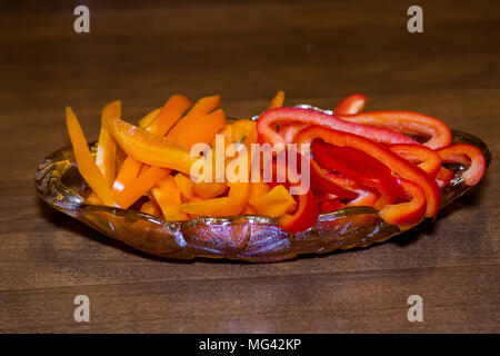 In Scheiben geschnitten, orange und rote Paprika in einer Schale serviert. Stockfoto