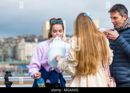 Junge Mädchen mit Zuckerwatte (Zuckerwatte, Zuckerwatte) am Meer am Pier von Brighton, East Sussex, England, UK. Stockfoto