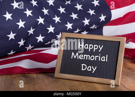 Happy Memorial Day auf einer Schiefertafel mit der amerikanischen Flagge im Hintergrund Stockfoto