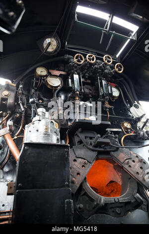 Niedriger Winkel Blick in Dampflokomotive Kabine von Taw Valley, Brandschutztüren offen zeigt orange Wärme glühen brennenden Brennstoff in der Brennkammer. Stockfoto