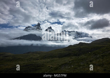 Cerro Paine Grande und Berge inmitten der Wolken. Panorama. Weite Einstellung. Stockfoto