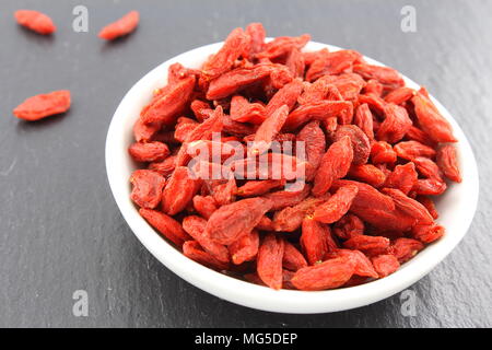 Zusammensetzung der getrockneten Goji-Beeren in eine kleine Schüssel weiß Stockfoto