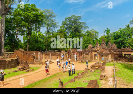 Touristen zu Fuß auf dem Damm vor der East gopura des dritten Gehäuse in der Kambodschanischen Banteay Srei (Zitadelle der Frauen) Tempel. Stockfoto