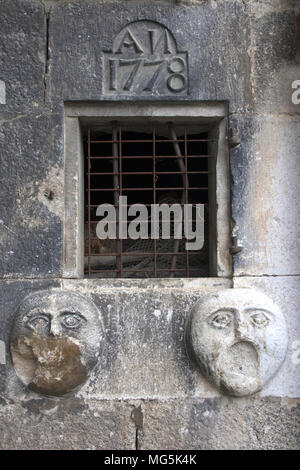 Kleine, quadratische Fenster mit Steinmetzarbeiten um ihn herum, in Mosset, einem kleinen Dorf auf einem Hügel in den Pyrénées-Orientales Abteilung in Süd frankreich. Stockfoto