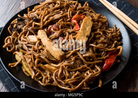 Veggie Nudelsuppe mit Tofu und Rote Paprika auf schwarzem Teller. Traditionelle Speisen. Stockfoto