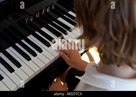 Ein Junge mit sechs Jahren, Klavier zu spielen Stockfoto