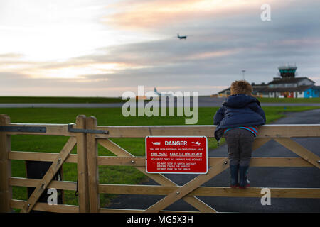 Ein kleiner Junge beobachten die Flugzeuge landen bei St Marys Airport auf den Scilly-Inseln Stockfoto